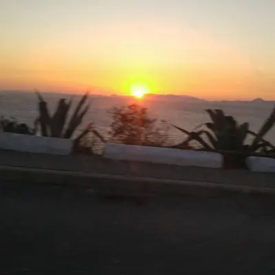 a sunset over the ocean as the sun sets at Romantic rooms with stunning sea view in Rhodes Town