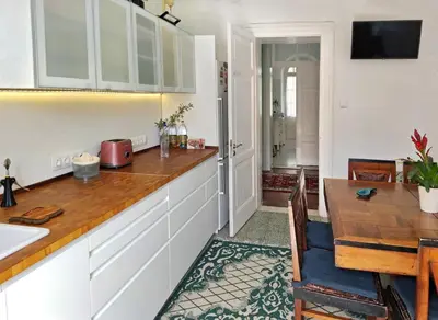 a kitchen with white cabinets and a dining table at Romantic rooms with stunning sea view in Rhodes Town