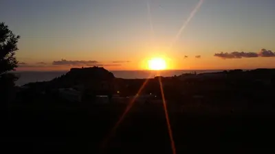 a sunset with the sun setting over the ocean at LINDOS HORIZON in Líndos
