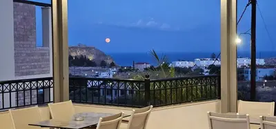 a balcony with a table and chairs and a view of the ocean at LINDOS HORIZON in Líndos