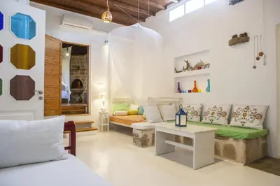 a living room with a couch and a table at Oliveyard Stone Built House- with pool non chlorin in Koskinou