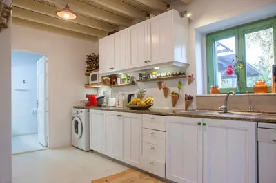 a kitchen with a sink and a washing machine at Oliveyard Stone Built House- with pool non chlorin in Koskinou