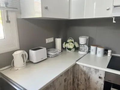 a kitchen with white appliances on a counter at La Casa de Tsampika in Koskinou