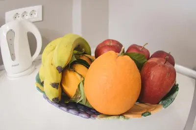a bowl of fruit on a counter with apples and bananas at La Casa de Tsampika in Koskinou