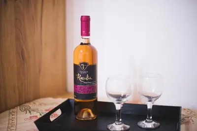 a bottle of wine sitting next to two wine glasses at La Casa de Tsampika in Koskinou