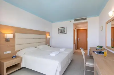 a bedroom with a large white bed and a desk at Blue Horizon in Ialyssos