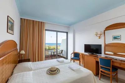 a hotel room with a bed and a desk and a television at Blue Horizon in Ialyssos