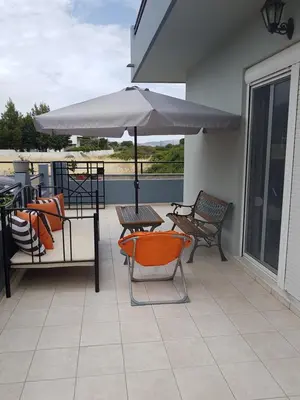 a patio with chairs and a table and an umbrella at Villa Anastasia in Gennadi