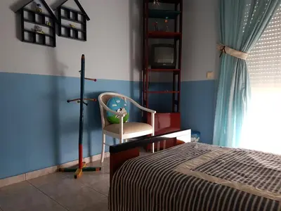 a bedroom with a bed and a chair and a window at Villa Anastasia in Gennadi