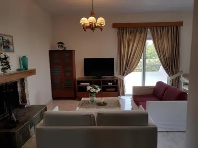 a living room with a couch and a tv at Villa Anastasia in Gennadi