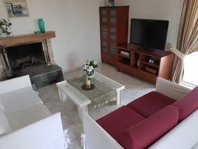 a living room with a couch and a tv at Villa Anastasia in Gennadi