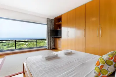 a bedroom with a bed and a large window at Rhodes Sunrise Maisonette in Koskinou