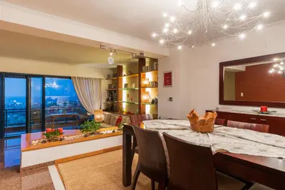 a dining room with a table and a large window at Rhodes Sunrise Maisonette in Koskinou