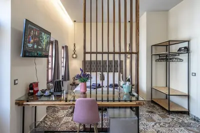 a room with a desk and a pink chair at Casa Poli Suites in Rhodes Town