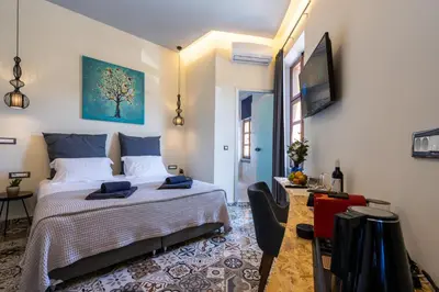 a bedroom with a bed and a tv on a wall at Casa Poli Suites in Rhodes Town