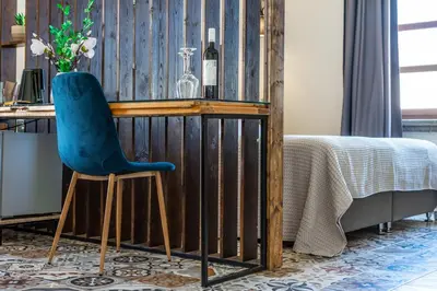 a blue chair sitting at a desk with a bottle of wine at Casa Poli Suites in Rhodes Town