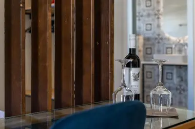 a bottle of wine and two glasses on a table at Casa Poli Suites in Rhodes Town