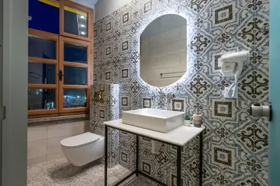 a bathroom with a sink and a mirror and a toilet at Casa Poli Suites in Rhodes Town