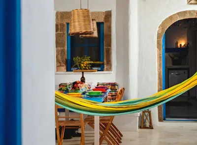 a table with a hammock in a dining room at Villa Kefi in Koskinou