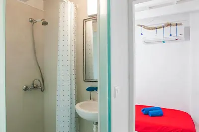 a bathroom with a sink and a toilet and a mirror at Villa Kefi in Koskinou
