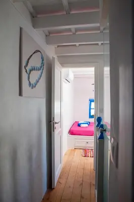 a hallway with a bedroom with a red bed at Villa Kefi in Koskinou