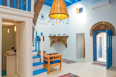 a living room with blue stairs and a chandelier at Villa Kefi in Koskinou