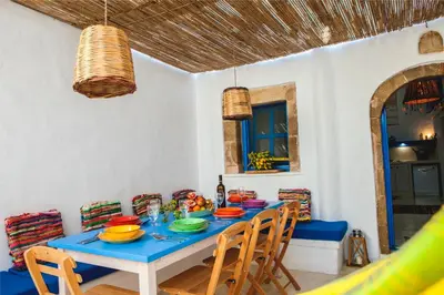 a dining room with a blue table and chairs at Villa Kefi in Koskinou