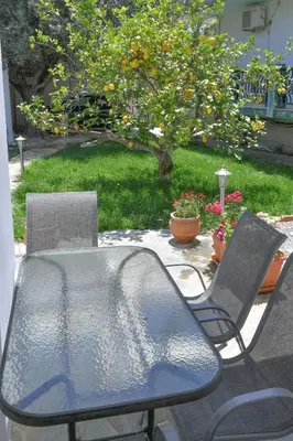 a table and chairs sitting on a patio at The Olive Garden House in Haraki