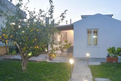 an orange tree in front of a house with lights at The Olive Garden House in Haraki