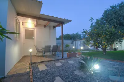 a patio with a table and chairs in a yard at The Olive Garden House in Haraki