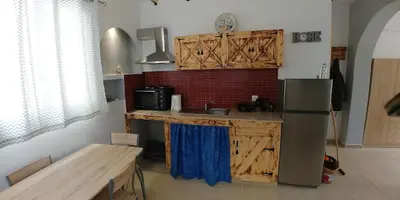 a kitchen with wooden cabinets and a refrigerator and a table at BEAUTIFUL HOUSE OF PSINTHOS in Psinthos