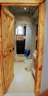 a bathroom with a wooden door and a toilet at BEAUTIFUL HOUSE OF PSINTHOS in Psinthos