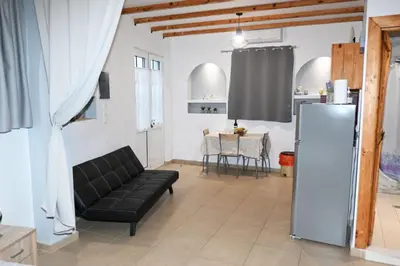 a living room with a black couch and a refrigerator at BEAUTIFUL HOUSE OF PSINTHOS in Psinthos