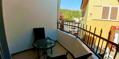 a balcony with a chair and a table and a window at BEAUTIFUL HOUSE OF PSINTHOS in Psinthos