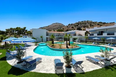 a pool with chairs and umbrellas in a resort at Paradise Garden in Kolimbia