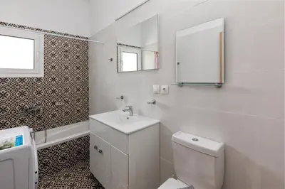 a white bathroom with a toilet and a sink at Paradise Garden in Kolimbia