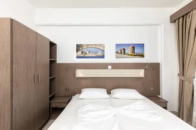 a bedroom with a large white bed in it at Paradise Garden in Kolimbia