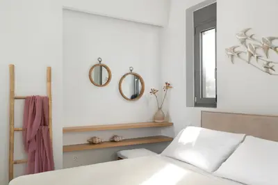 a bedroom with a bed and two mirrors on the wall at Terpsis Pool Villa in Rhodes Town