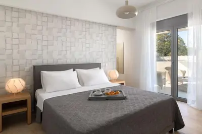 a bedroom with a bed with a tray of food on it at Terpsis Pool Villa in Rhodes Town