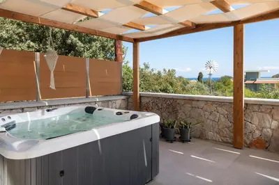 a hot tub on the patio of a house at Terpsis Pool Villa in Rhodes Town