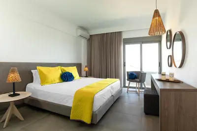 a bedroom with a bed with yellow and blue pillows at MIRAGE city APARTMENTS in Rhodes Town