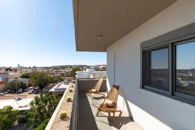 a balcony with two chairs and a view of the city at MIRAGE city APARTMENTS in Rhodes Town