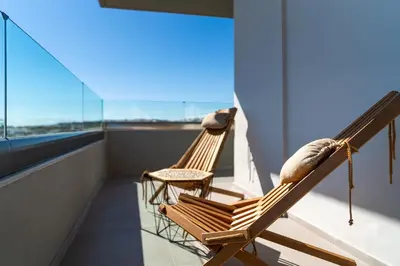 two rocking chairs on the balcony of a building at MIRAGE city APARTMENTS in Rhodes Town