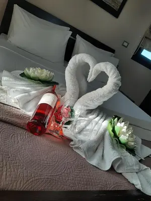 a bed with two swans and a bottle and flowers at Rhodian Villa in Kremasti