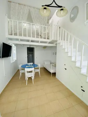a living room with a table and a staircase at Pontamos Villas in Halki
