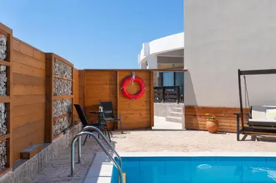 a house with a swimming pool and a patio at Ifigeneia Villa in Afantou