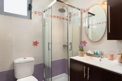 a bathroom with a shower and a toilet and a sink at Ifigeneia Villa in Afantou