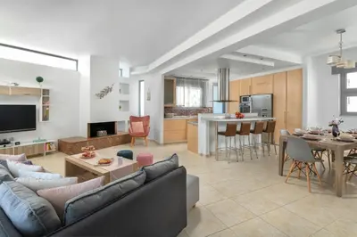 a living room and kitchen with a couch and a table at Ifigeneia Villa in Afantou