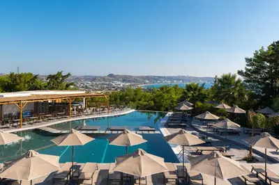 a large swimming pool with umbrellas and chairs at Atalanti Boutique Hotel - Adults Only in Faliraki