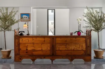 a wooden dresser in a room with two plants at Atalanti Boutique Hotel - Adults Only in Faliraki